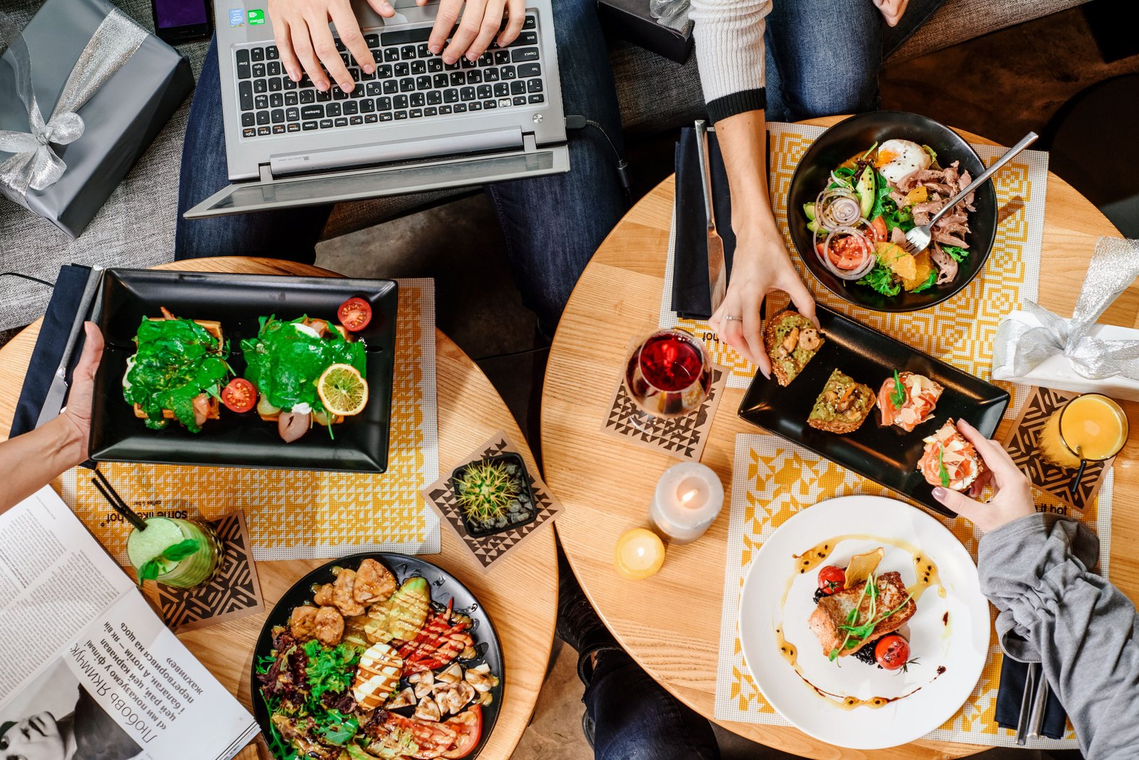 Echte Restauranttische mit Essen und Laptop